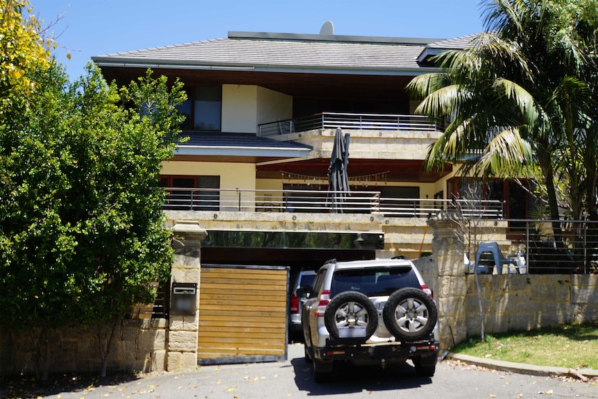 A fancy house with a car parked out the front.