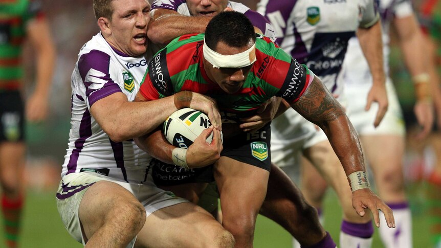 Souths' Jeff Lima is tackled by Melbourne's Ryan Hoffman and Cameron Smith.
