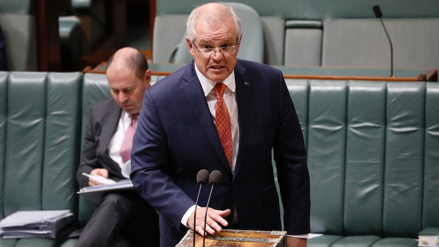 PM Scott Morrison standing at the lectern in Question Time.