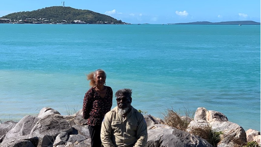 A man and woman sitting on the rocks on the island of Muralag in the Torres Strait
