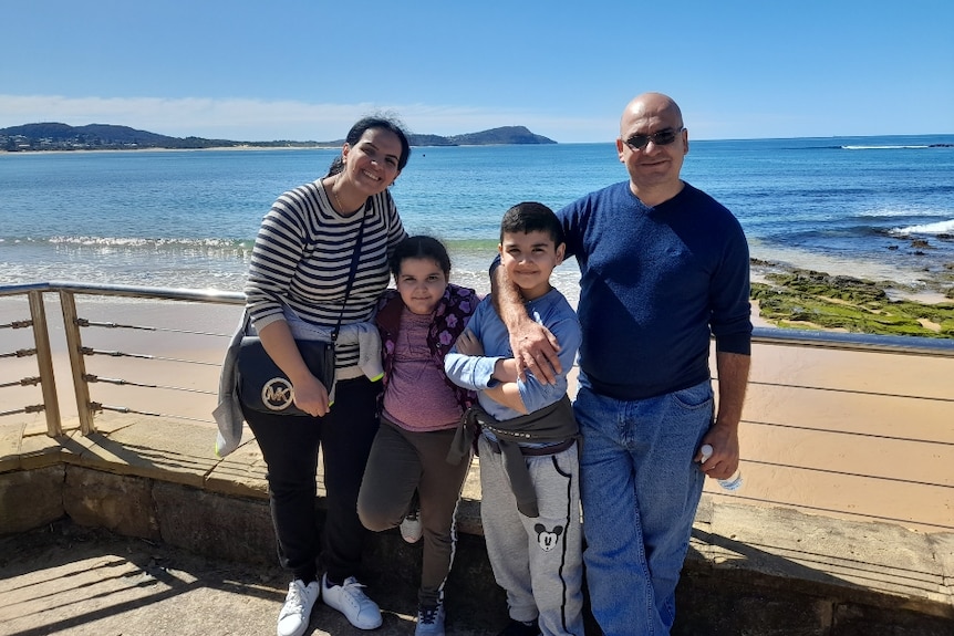 The Al Daoud family - arms around each other with Terrigal beach in the background. 