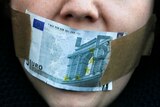 Protester covers mouth with a five Euro bill during a demonstration against banking and finance.