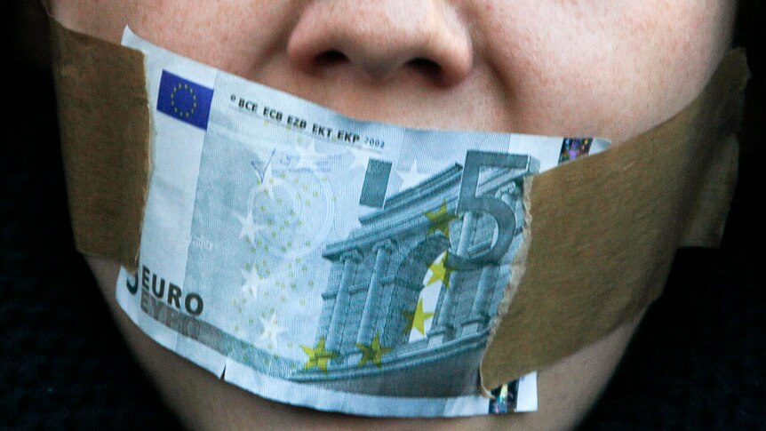 Protester covers mouth with a five Euro bill during a demonstration against banking and finance.