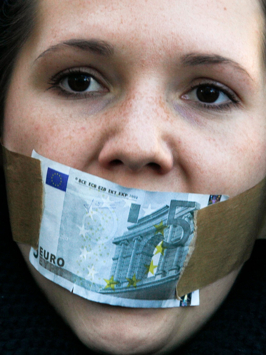 Protester covers mouth with a five Euro bill during a demonstration against banking and finance.