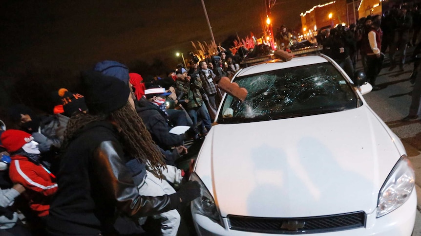 Ferguson protesters vandalise a police car