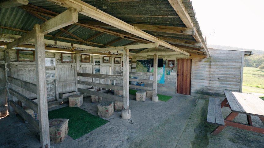 A really old dairy milking shed has been cleaned up with seating and tables for tourists to enjoy