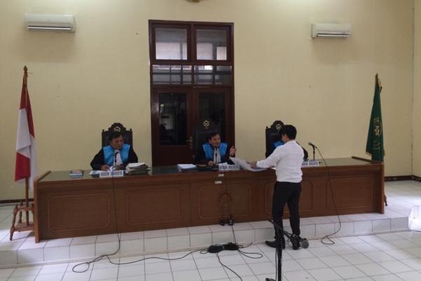 A lawyer for the Indonesian president stands before three judges.