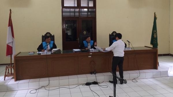 A lawyer for the Indonesian president stands before three judges.