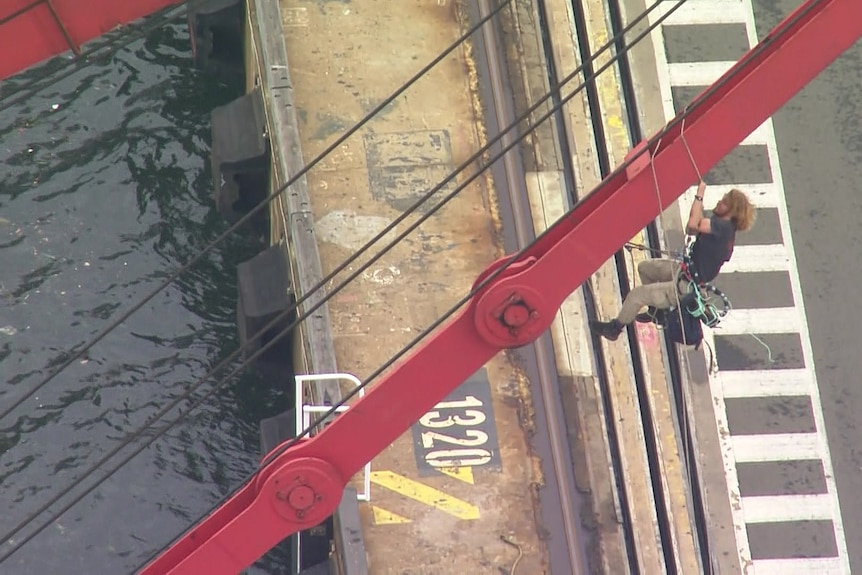 a young man suspended from a crane outdoors