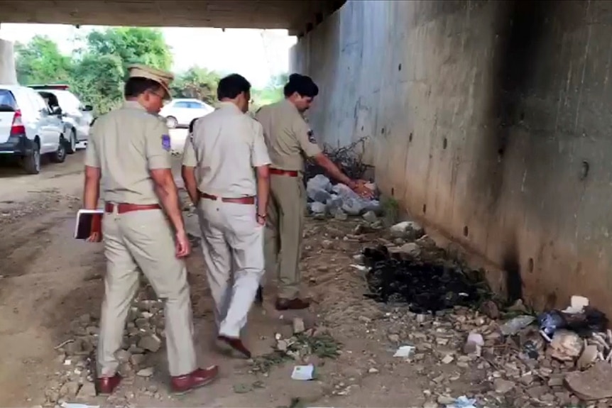 Police officers inspect crime scene