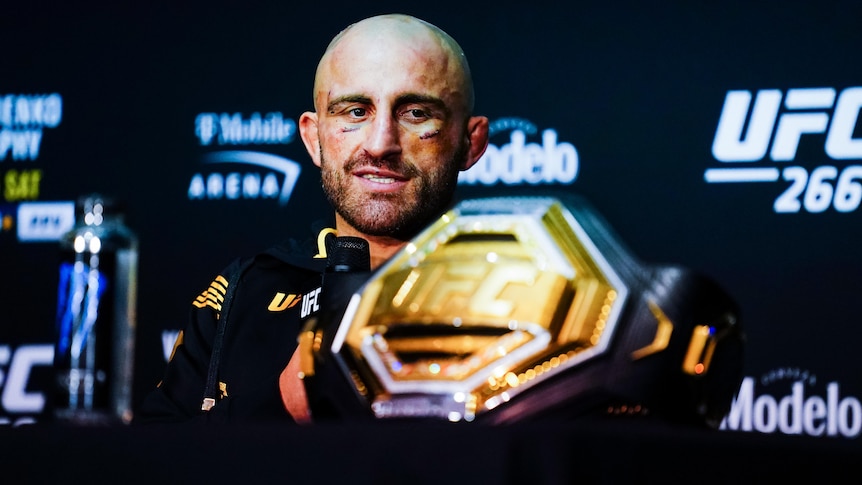 A fighter looks at his UFC championship belt 