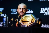 A fighter looks at his UFC championship belt 
