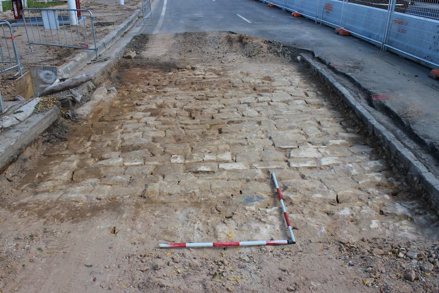 Sandstone bricks are seen underneath a roadway.