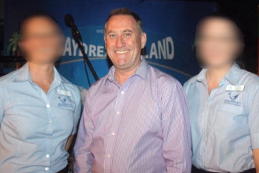 A man with the blurred faces of two women each side of him.
