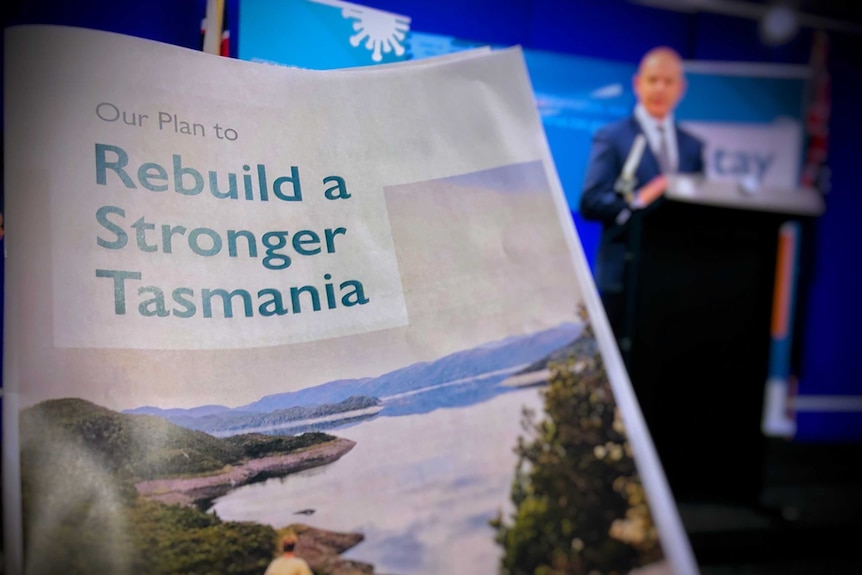 Tasmanian Road to Recovery document in foreground with Premier Peter Gutwein in background