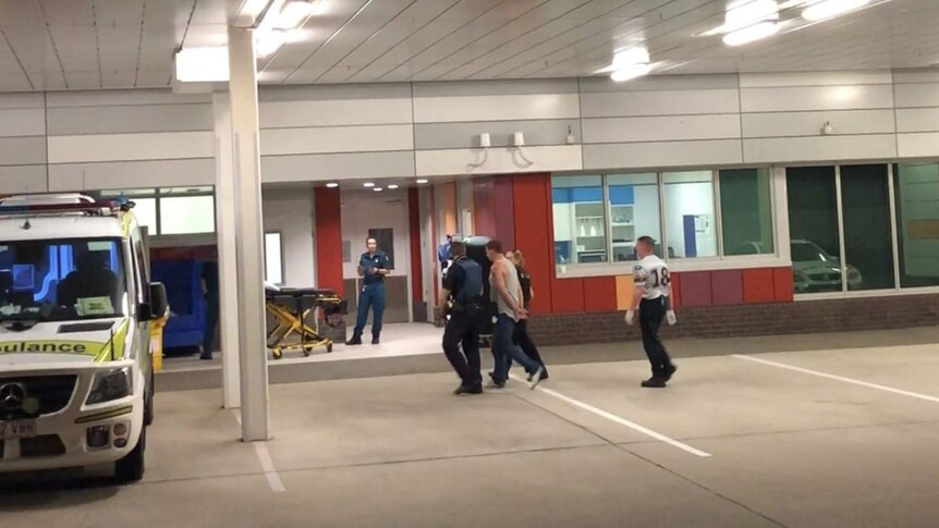 Police escorting the man into Mackay hospital