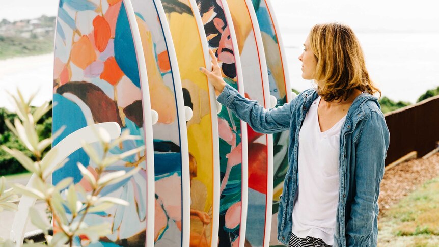 Nusa Indah CEO Jada McNeil with row of colourful surfboards