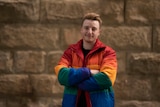 A person wearing a rainbow-flag jacket.