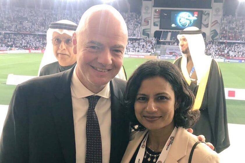 FIFA president Gianni Infantino puts his arm around Mariyam Mohamed at a football stadium.