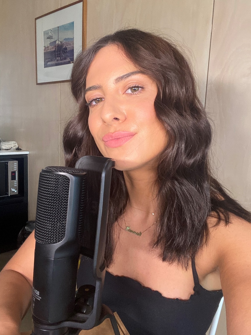 Woman poses in front of microphone