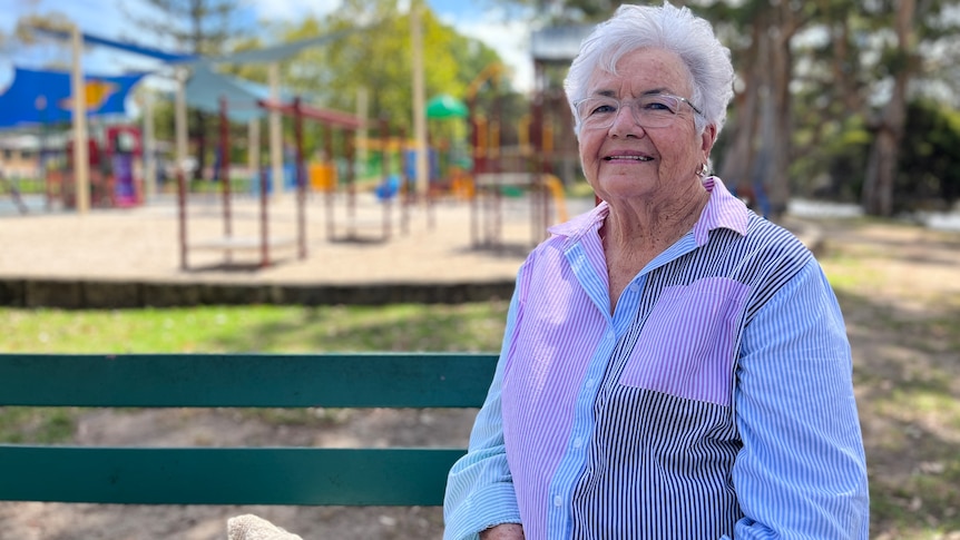 a woman sits on a park bench