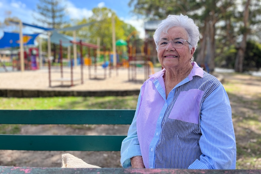 a woman sits on a park bench