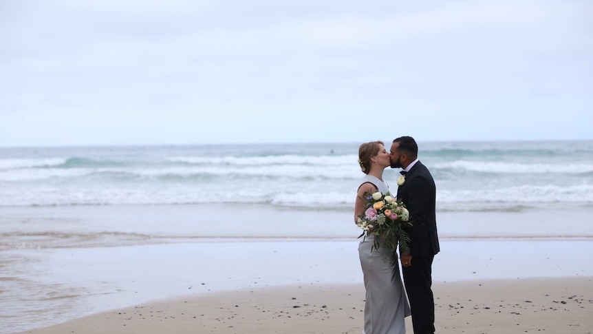 Couple Helen and Tony Stevens kiss on the Great Ocean Road.