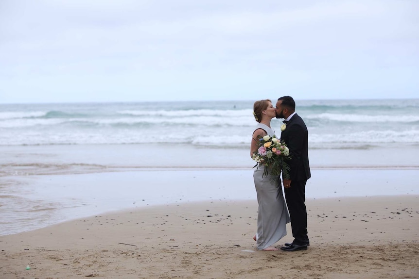 Couple Helen and Tony Stevens kiss on the Great Ocean Road.