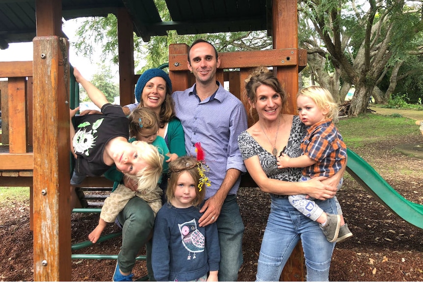 A group of adults and children next to a playground