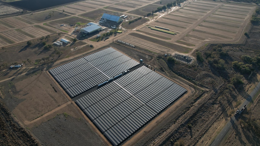 An aerial shot of a solar farm with other buildings 
