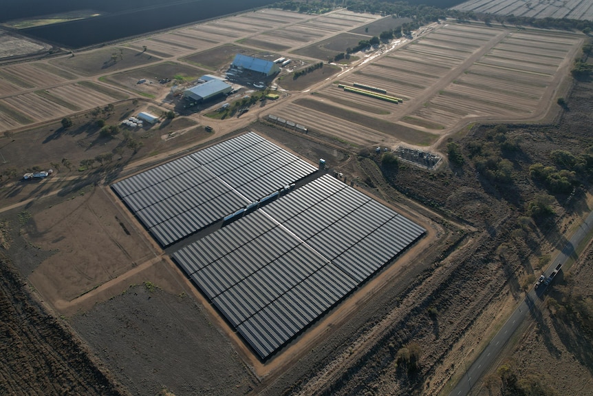 An aerial shot of a solar farm with other buildings 