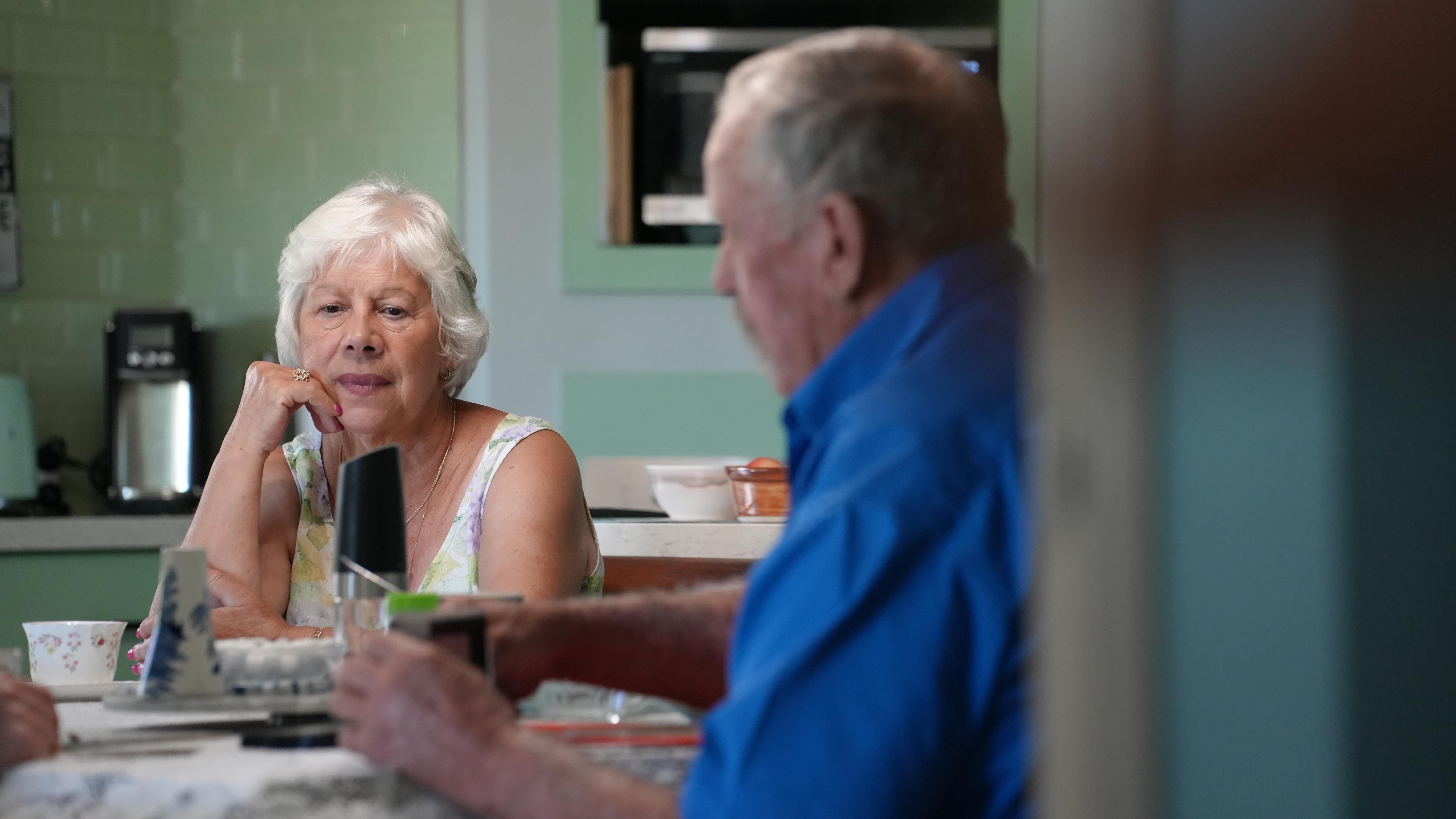 um homem e uma mulher sentam-se à mesa. 