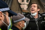 A shouting man being held by police
