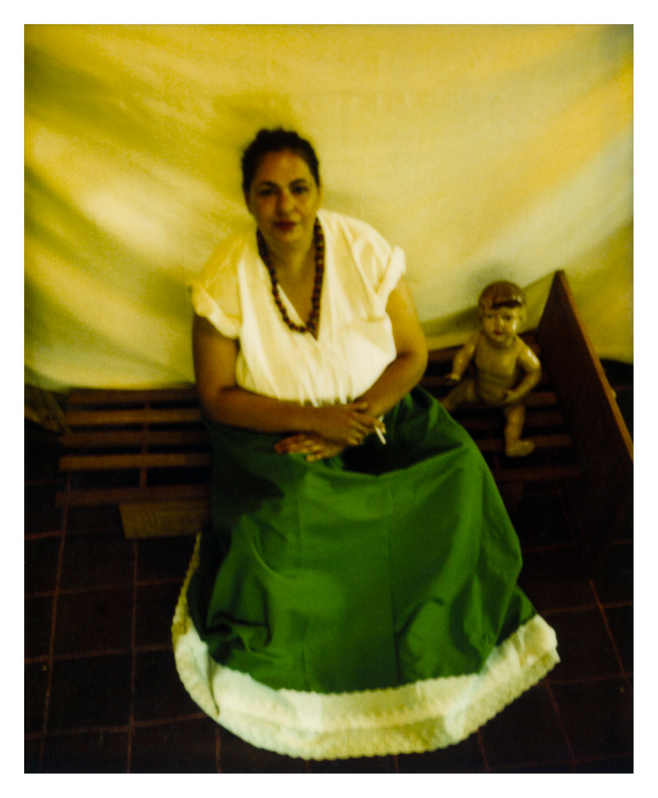 A 90s photograph of the artist Destiny Deacon as Frida Kahlo, a doll next to her