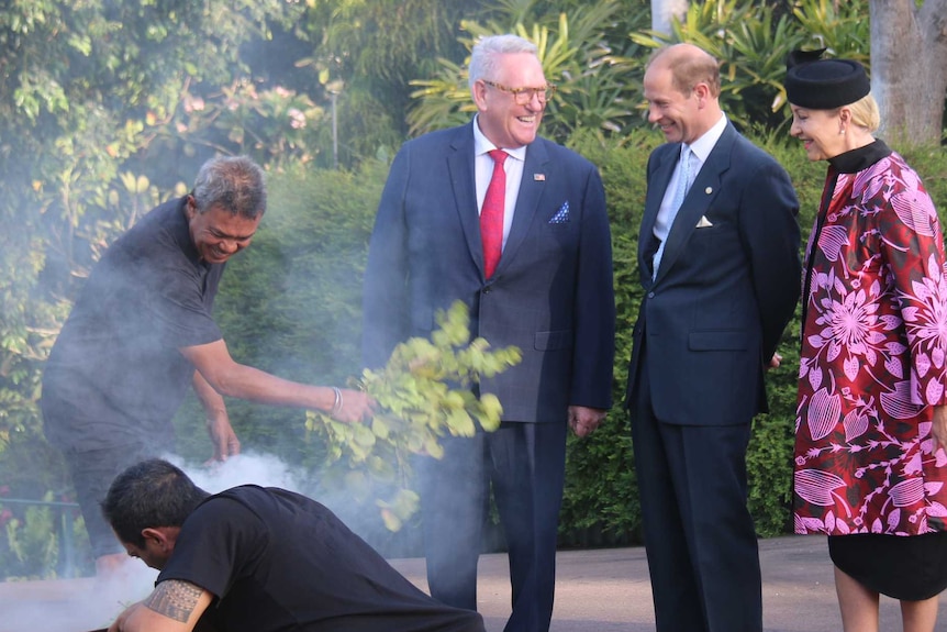 Prince Edward shares in a smile with his entourage during a smoking ceremony outside Government House.