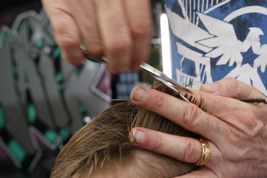Close up image of child getting hair cut.