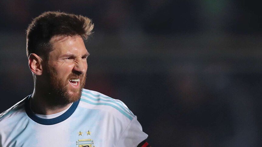 A head shot of Lionel Messi scrunching his face in celebration