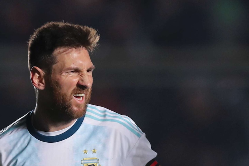 A head shot of Lionel Messi scrunching his face in celebration