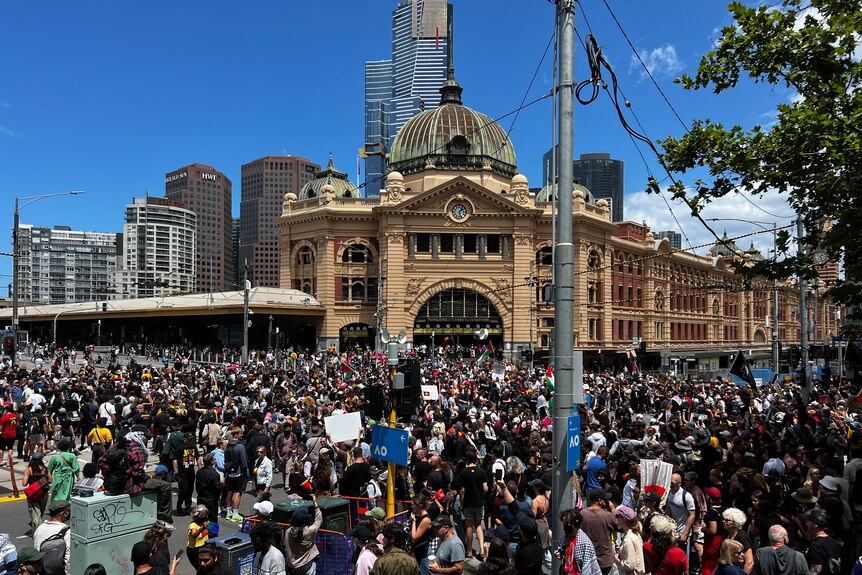 Protesters fill the intersection in front of Flinders Street Station.