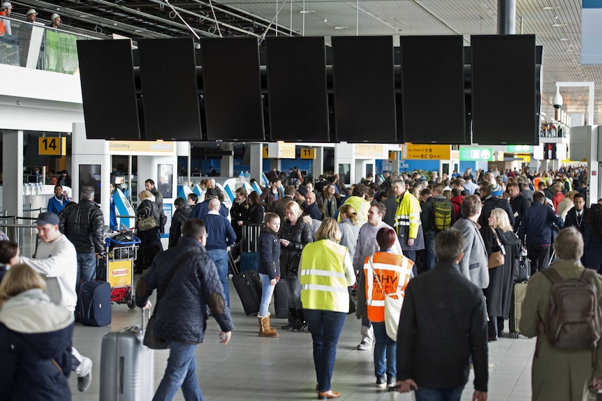 Passengers wait at Schiphol Airport
