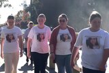 A group of young woman walking, wearing t-shirts with a woman's photo and the words "Her name is Molly".