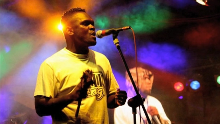 Two people on stage with colourful lighting.
