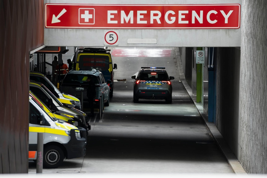 Several ambulances parked in emergency entrance to hospital. 