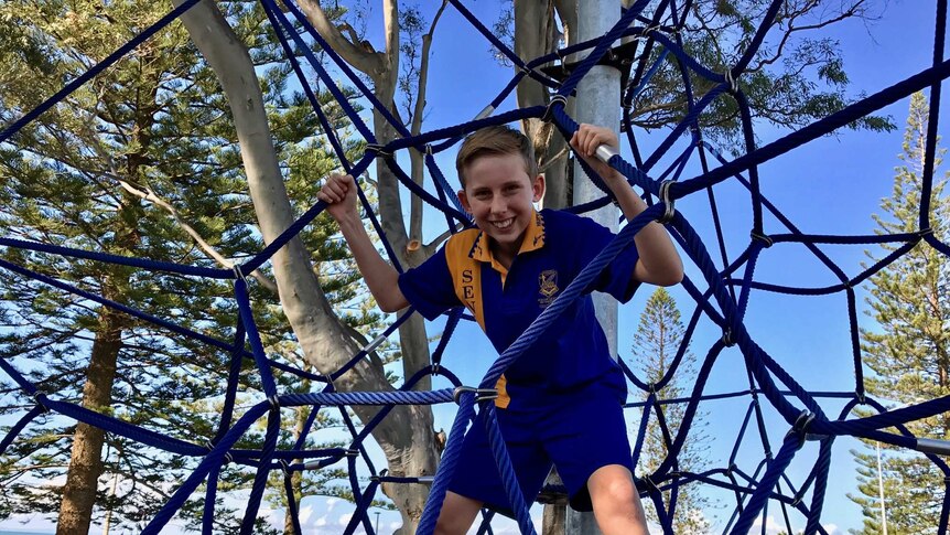 Xavier loves using the spider web at the shared playground