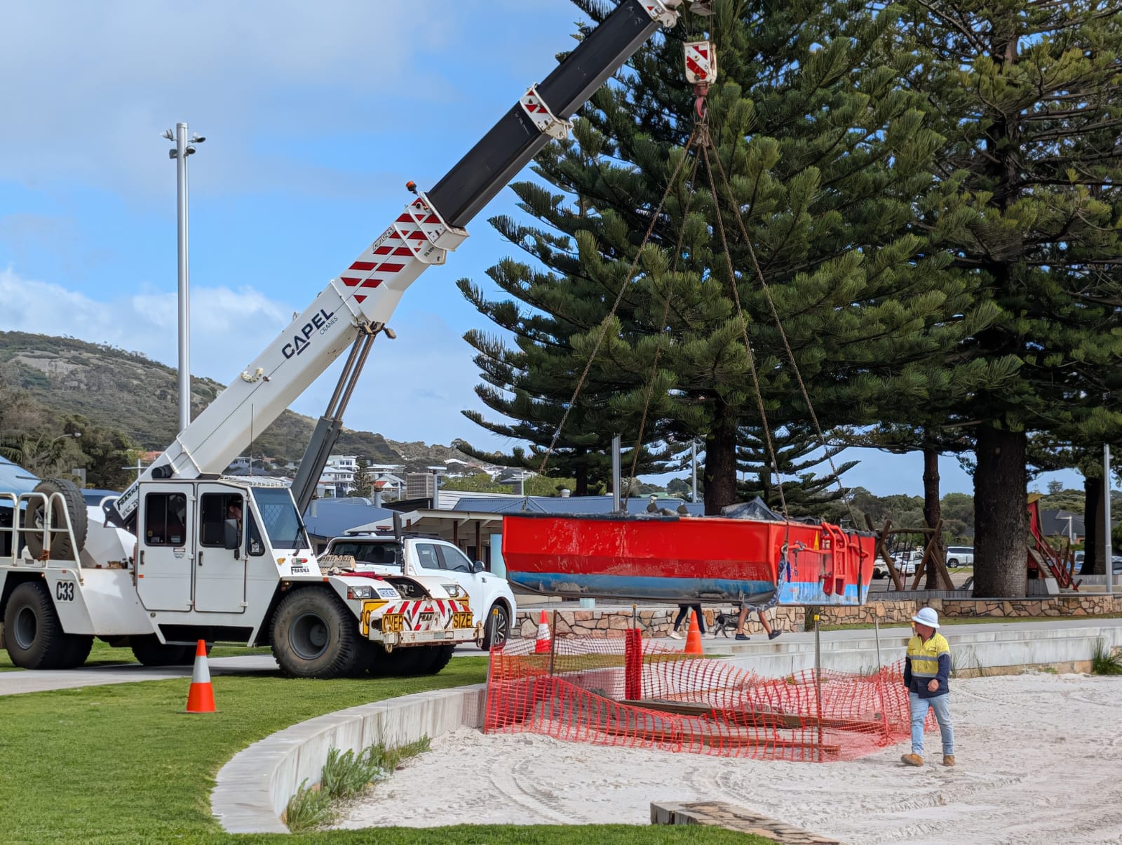 A crane lifts the pontoon into the air