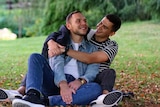 Vladyslav Guz and his boyfriend sit in the park. They fled the war in Ukraine.