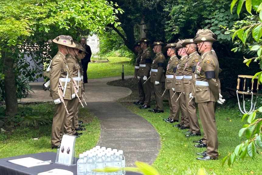 Soldiers in full dress uniform along a footpath