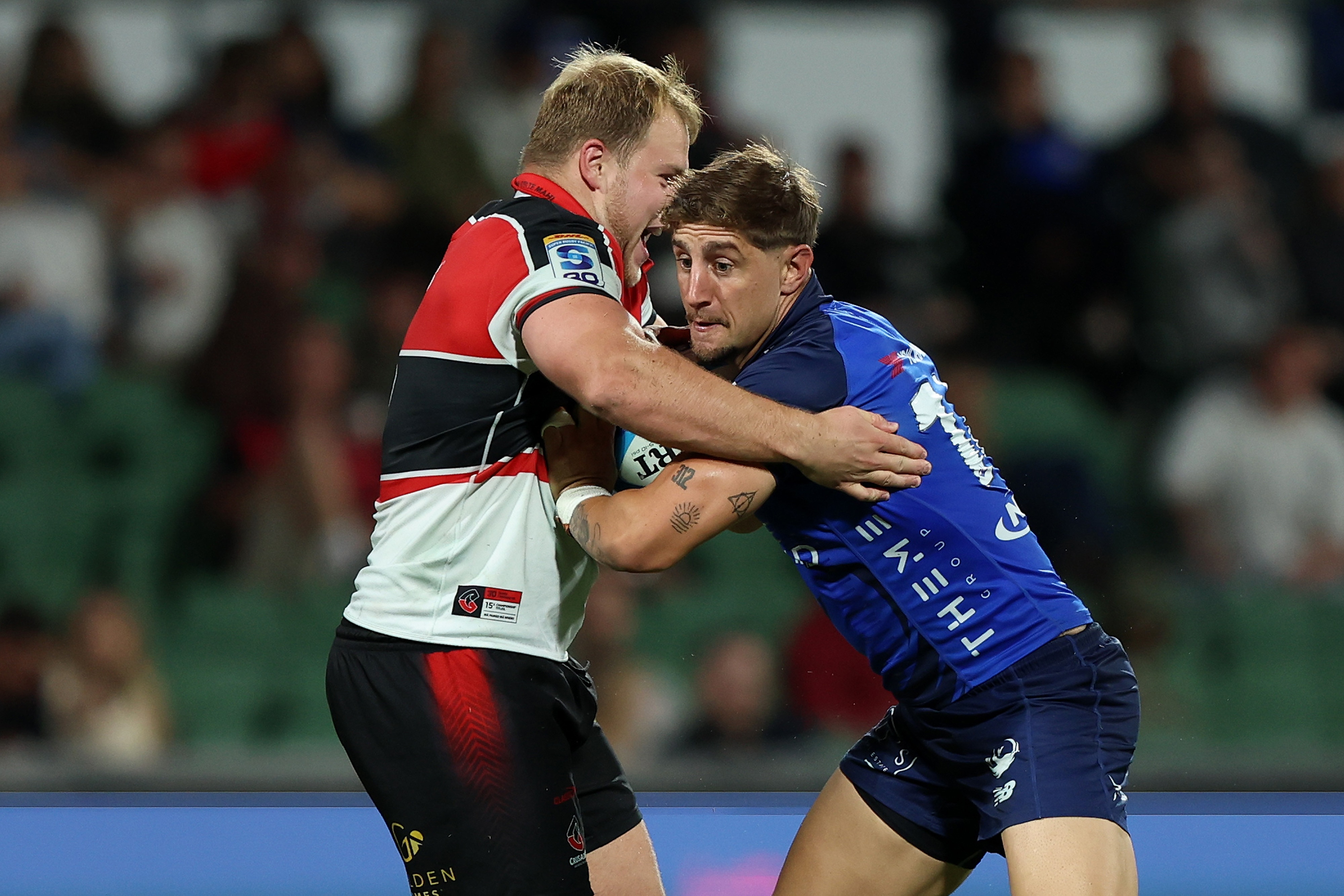 Western Force's Zac Lomax holds the ball while being tackled by a Crusaders opponent.