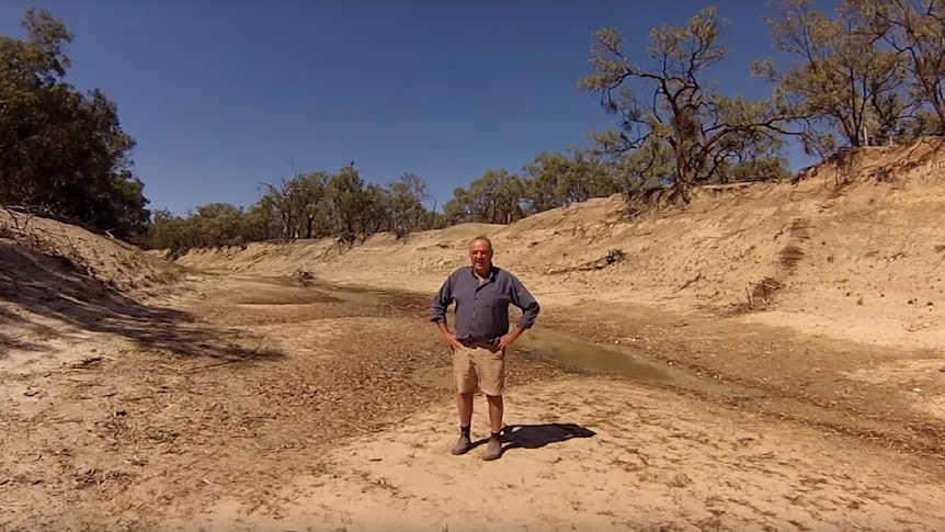 Lower Darling River farmer Rob McBride shows the dry river bed of the Lower Darling River