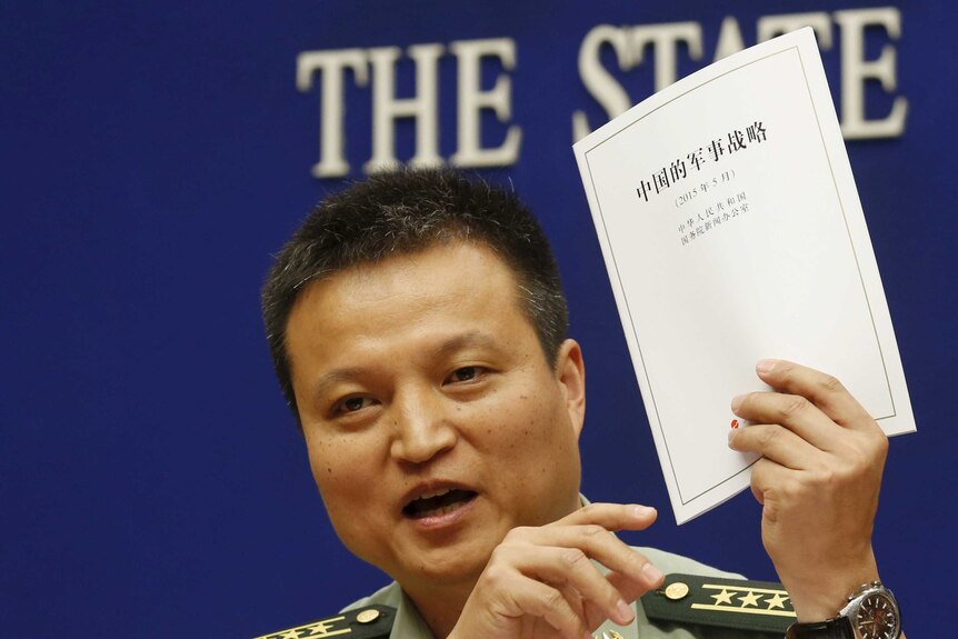 Chinese defence ministry spokesman Yang Yujun holds a copy of Beijing's white defence paper